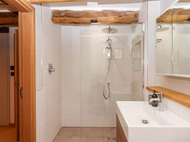 A bathroom with a shower and sink at Lower Walreddon Barn Tavistock