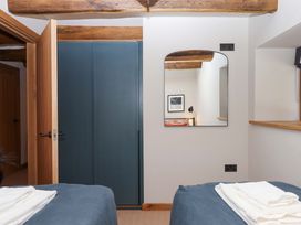 A bedroom with a mirror and bed at Lower Walreddon Barn Tavistock