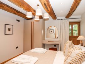 A bedroom with a bed and wardrobe at Lower Walreddon Barn in Tavistock