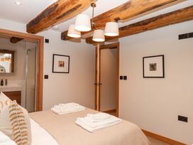 A bedroom with a bed and towels at Lower Walreddon Barn in Tavistock