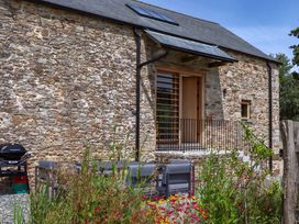 An outdoor area with stone wall and seating at Lower Walreddon Barn Tavistock