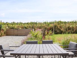 A garden with a table and chairs at Lower Walreddon Barn in Tavistock