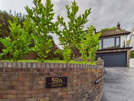 A house with plants and a driveway at 59A Pemburry