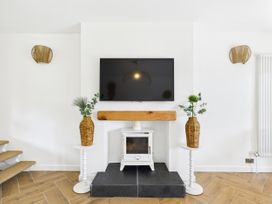 A living room with a television and fireplace at 59a Gwscwm Road
