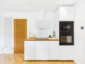 A kitchen with appliances and a door at 59a Gwscwm Road