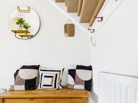 A hallway with a wooden bench and cushions at 59a Gwscwm Road
