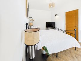 A bedroom with a bed, lamp, and television at 59a Gwscwm Road