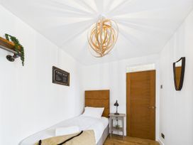 A bedroom with a single bed and door at 59a Gwscwm Road