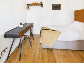 A bedroom with a bed, desk, and shelf at 59a Gwscwm Road