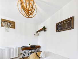 A bedroom with a bed, desk, and basketball hoop at 59a Gwscwm Road