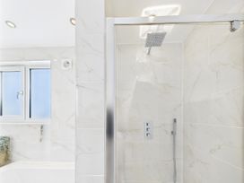 A bathroom with a shower and bathtub at 59a Gwscwm Road