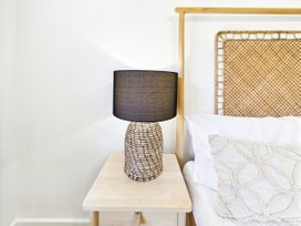 A lamp on a nightstand beside a bed at 59a Gwscwm Road