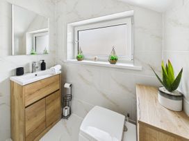 A bathroom with a sink and mirror at 59a Gwscwm Road