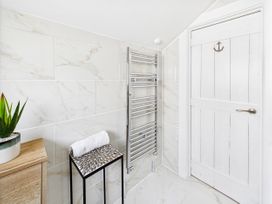 A bathroom with a towel rack and a plant at 59a Gwscwm Road 