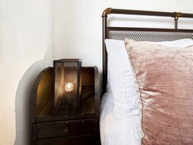 A bedroom with a bed and lamp on a nightstand at 59a Gwscwm Road