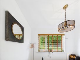 A room with a mirror, window with blinds, and a coat rack at 59a Gwscwm Road