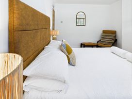 A bedroom with a bed and a chair at 59a Gwscwm Road