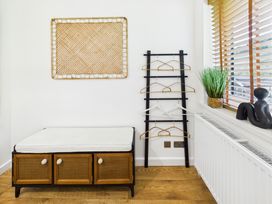 A hallway with a bench and wall art at 59a Gwscwm Road