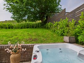 A hot tub with plants and a grassy area at 59a Gwscwm Road