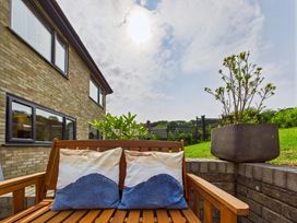 A garden with a wooden bench and cushions at 59a Gwscwm Road 