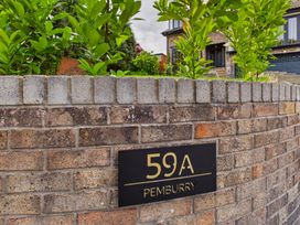 A brick wall with a house number sign at 59A Pemburry