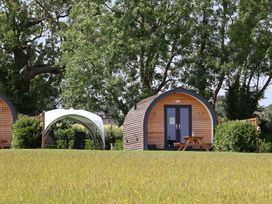 A wooden cabin and a tent in an outdoor area at Honeypot Hideaways - Manuka