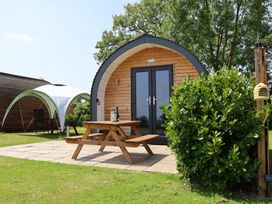 An outdoor cabin with a picnic table and chairs at Honeypot Hideaways - Manuka