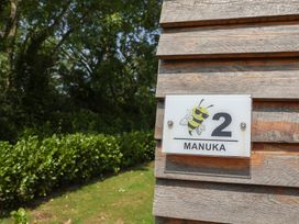 A sign with number 2 and the name Manuka in an outdoor area at Honeypot Hideaways - Manuka