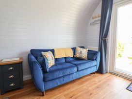 A snug room with a blue sofa and side table at Honeypot Hideaways - Manuka