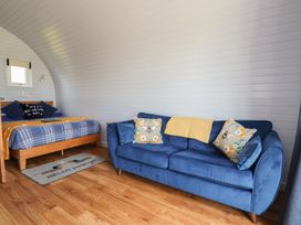 A bedroom with a bed and sofa at Honeypot Hideaways - Manuka