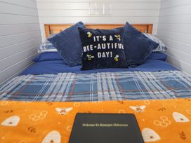 A bed with pillows and a notebook at Honeypot Hideaways - Manuka