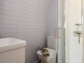 A bathroom with a toilet, shower and towel at Honeypot Hideaways - Manuka
