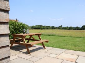 An outdoor picnic table with glasses and a bottle at Honeypot Hideaways - Manuka