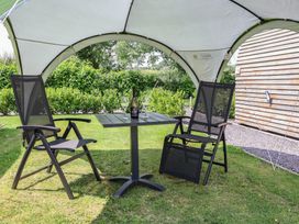 An outdoor seating area with a table and chairs at Honeypot Hideaways - Manuka