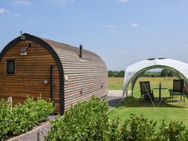 A wooden cabin and tent setup in an outdoor area at Honeypot Hideaways - Manuka