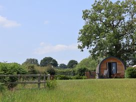A cabin with table and chairs in a garden at Honeypot Hideaways - Manuka