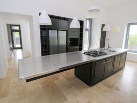 A kitchen with an island and gas stove at The Cottage in Ballinagleira