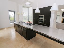 A kitchen with an island and modern appliances at The Cottage in Ballinagleira