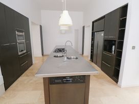 A kitchen with a central island featuring a stove and sink at The Cottage in Ballinagleira
