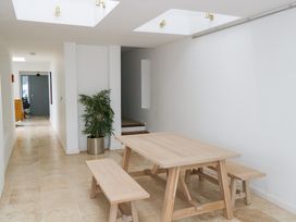 A dining room with a wooden table and benches at The Cottage in Ballinagleira
