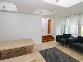 A dining area with a table and sofa at The Cottage in Ballinagleira
