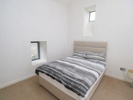 A bedroom with a bed and window at The Cottage in Ballinagleira
