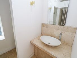 A bathroom with a sink and mirror at The Cottage in Ballinagleira