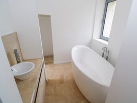 A bathroom with a bathtub and a sink at The Cottage in Ballinagleira