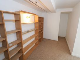 A storage room with wooden shelves and a light fixture at The Cottage in Ballinagleira