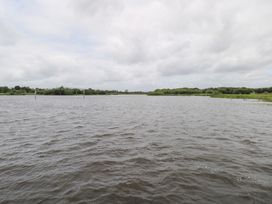 A river with vegetation and poles at The Cottage in Ballinagleira