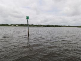 A view of water with navigation markers and houses at The Cottage in Ballinagleira