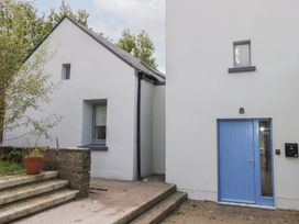 A house exterior with steps and a blue door at The Cottage in Ballinagleira