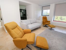 A living room with a sofa and chairs at The Cottage in Ballinagleira