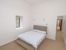 A bedroom with a bed and a window at The Cottage in Ballinagleira